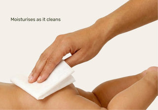 Hand using a white cloth to clean skin on a white background with text 'Moisturises as it cleans'.