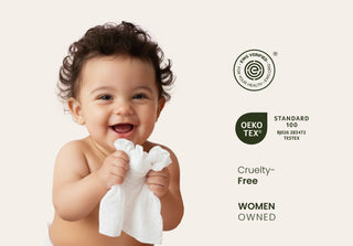 Baby holding cotton wipe with certification logos on the side.
