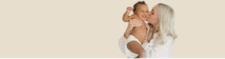 Mother holding and kissing baby
