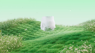 A white diaper floating in mid-air above a stylized green grassy hill with wildflowers under a pale mint-green sky.
